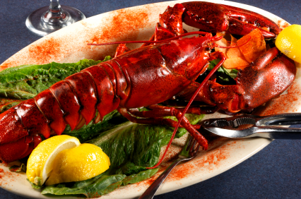 A nice red lobster on its plate with lettuce and lemon garnish: perfect for your next meal! Call us at 1-877-254-0222 to get yours today!